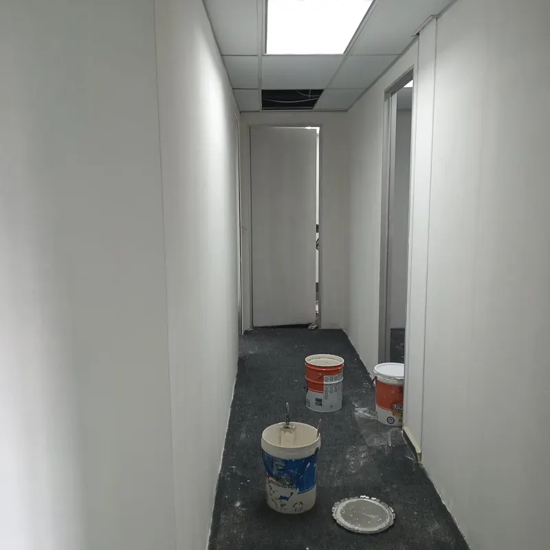 Newly painted office corridor with paint buckets and a roller