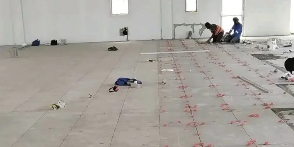 Large-format floor tiles being laid with levelling spacers
